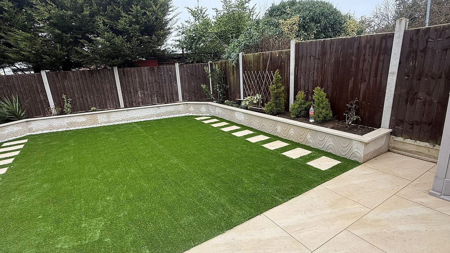 A landscaped Nottingham garden with a porcelain patio, new artificial lawn and rendered raised beds